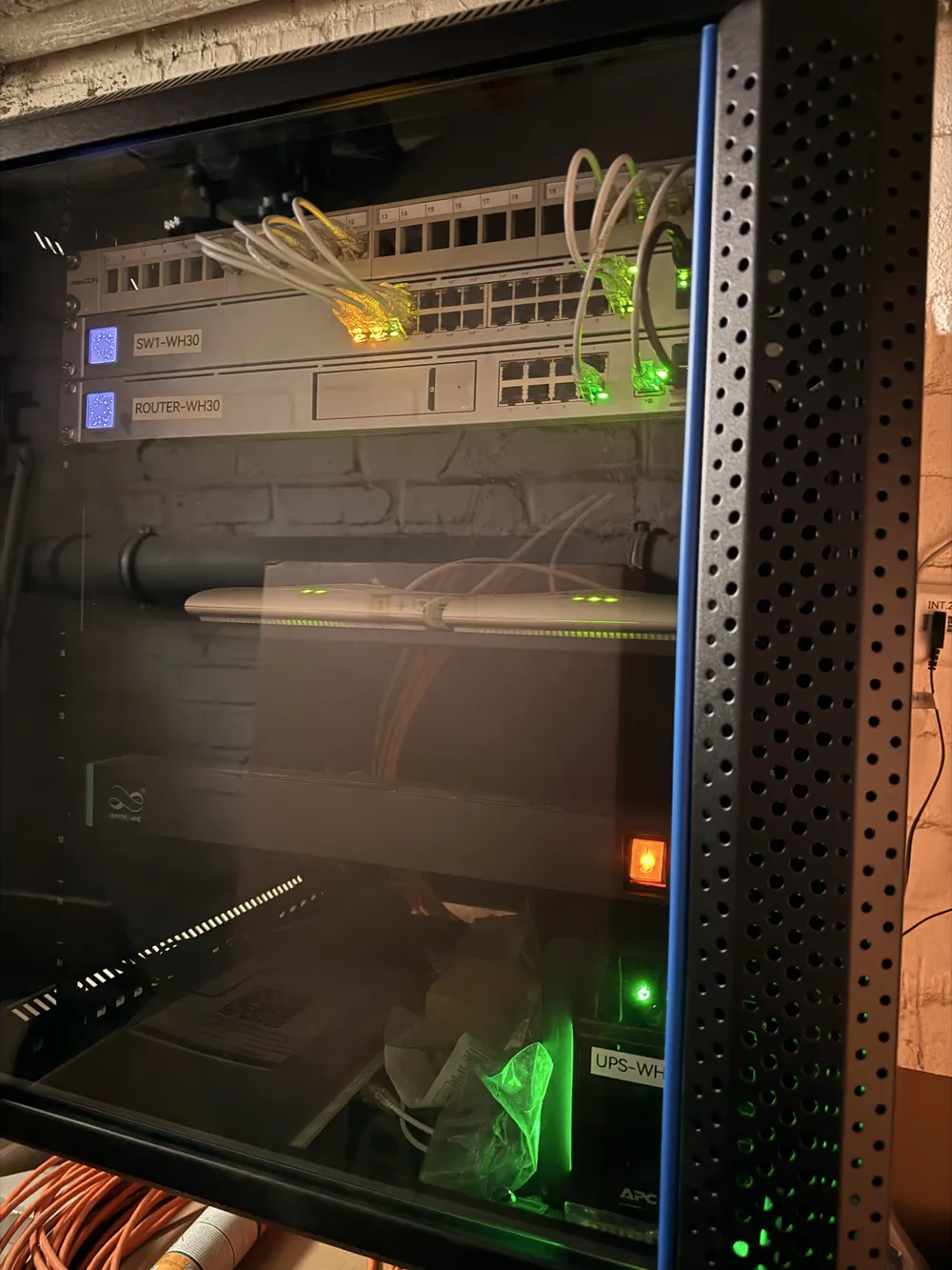 Netzwerkschrank mit beschriftetem Switch, Router und USV